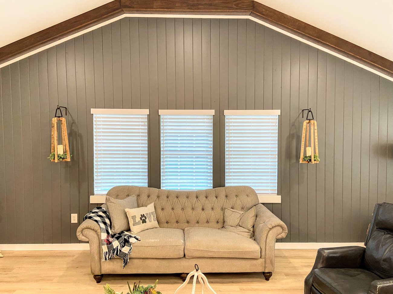 Faux wood blinds on a living room window wall by Love Is Blinds