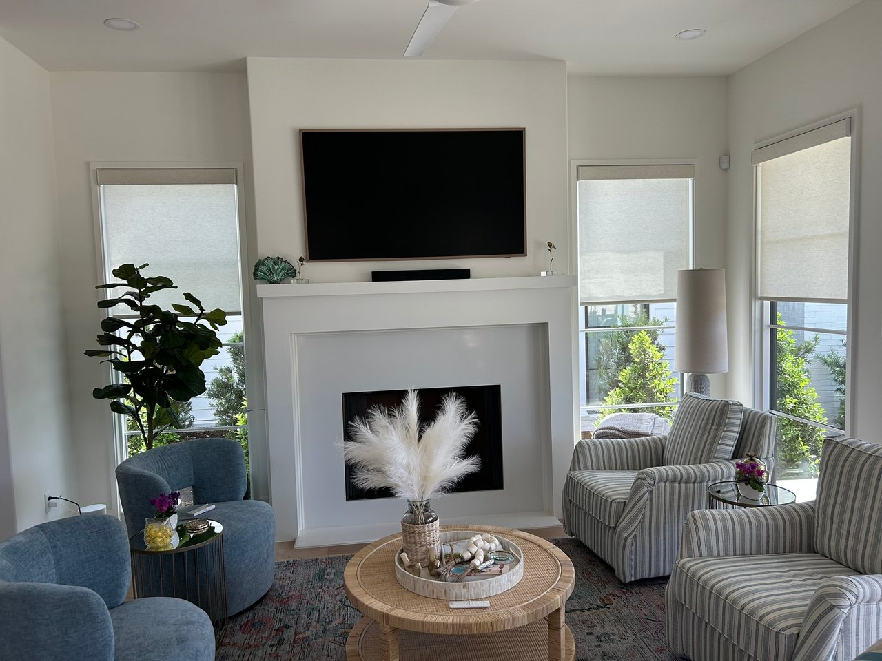 Warm living room with custom roller shades by Love Is Blinds