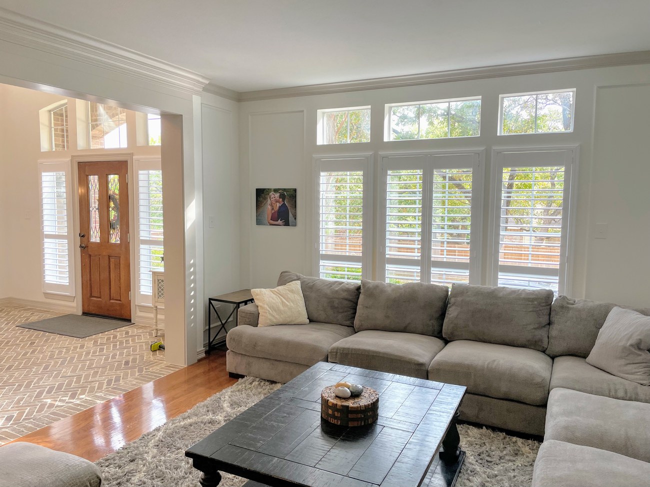Custom plantation shutters in a living room by Love Is Blinds